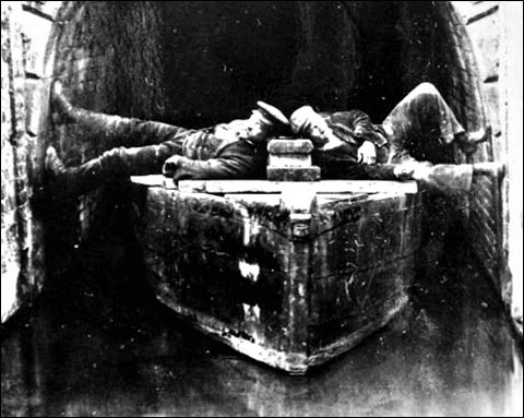 Photo of men legging a canal boat in a tunnel
