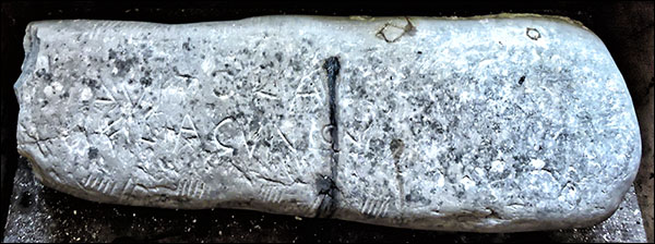 Photo of Ogham and Latin script on stone at Eglwys Gymyn