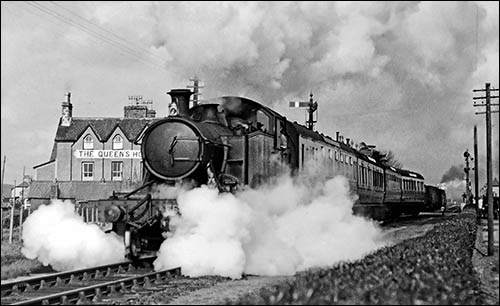 Old photo of steam train passing Queen's Hotel