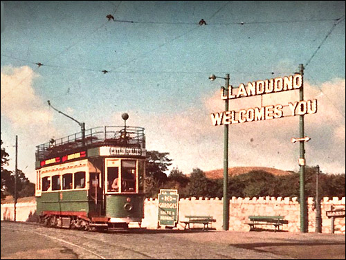 Old photo of tram passing welcome sign at Penrhyn Hill