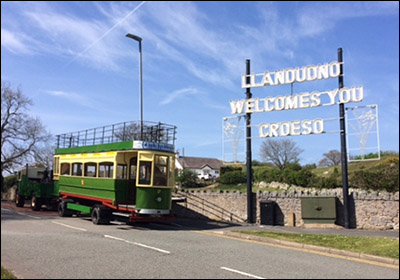 Photo of replica tram passing welcome sign at Penrhyn Hill