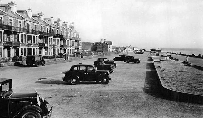 Old photo of Tywyn promenade with cars
